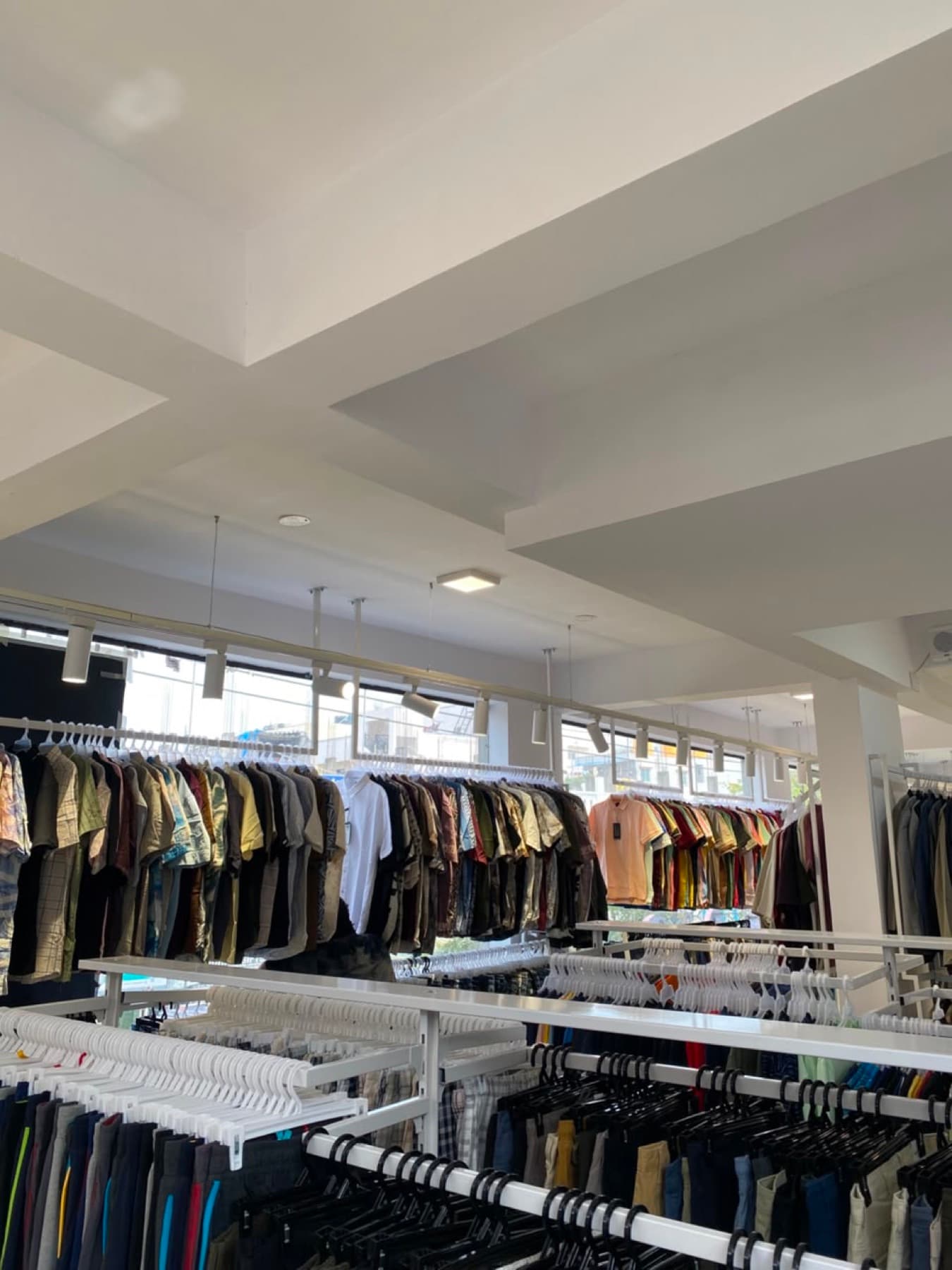 The main floor at Brantex, racks of shirts and trousers under skylights